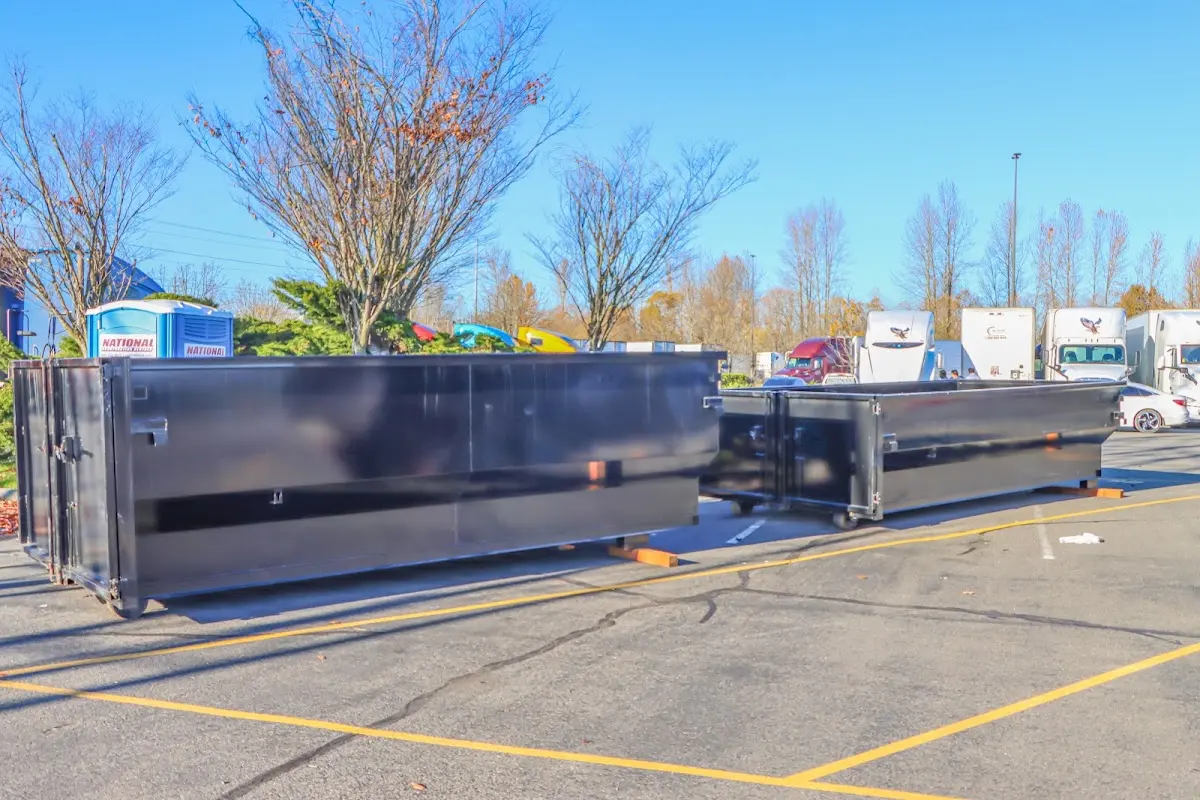 Professional dumpster rental service with roll-off container on residential driveway in Lower Salford